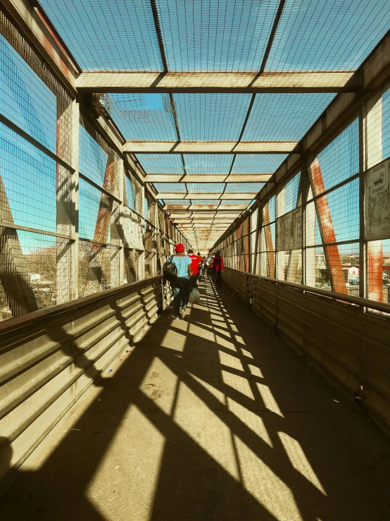 people are walking across an overpass with a blue sky