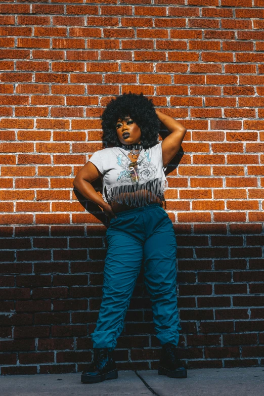 an image of a woman standing by a brick wall