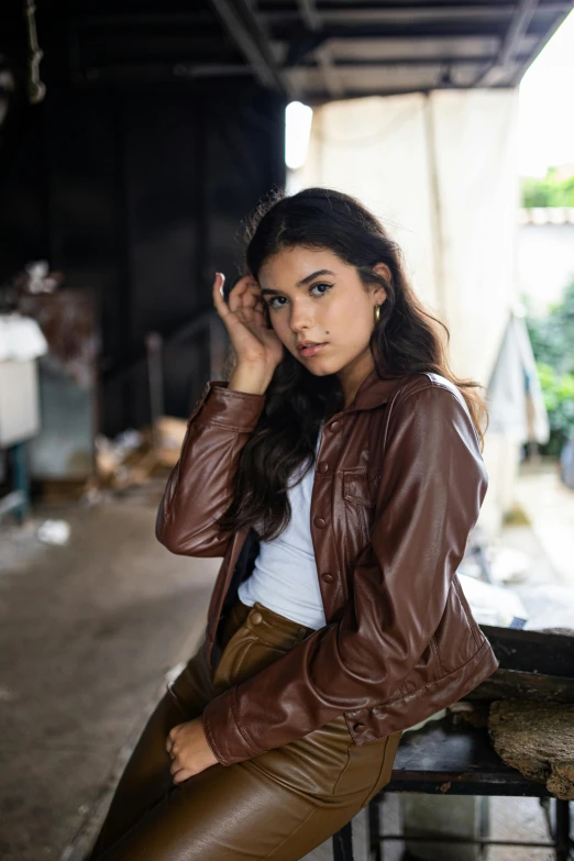 a woman is posing for a portrait while leaning against a rail