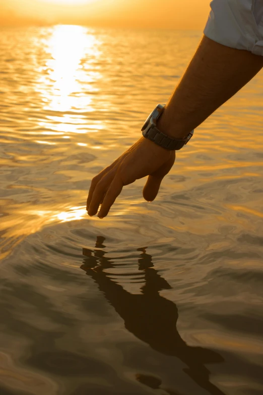 someone holding onto their wrist and walking into the water