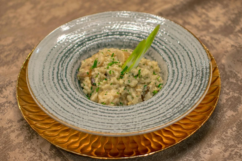 a bowl containing a creamy dish with green garnish