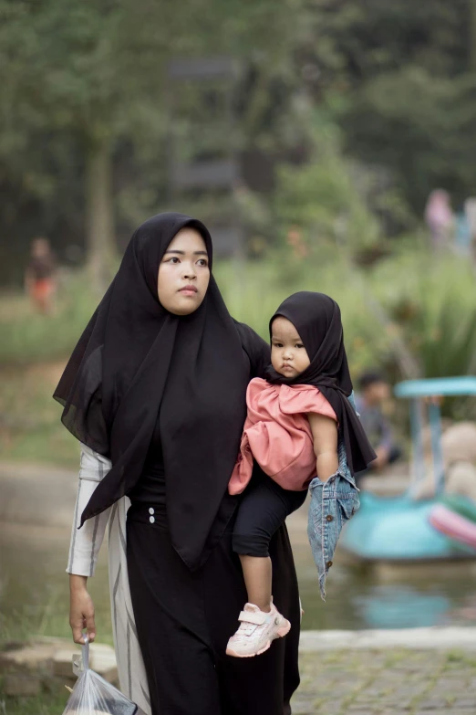 two women walking down the road with their child