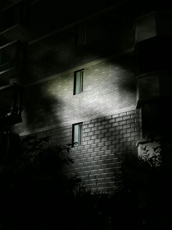 the silhouette of a brick building with two windows in it