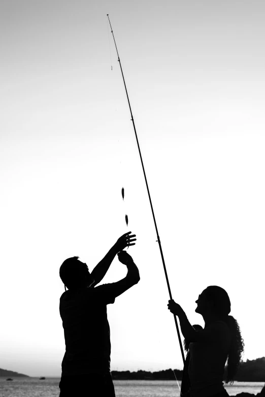 two people are trying to hold onto a fishing pole