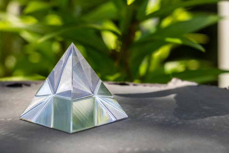 a small crystal pyramid on the black table