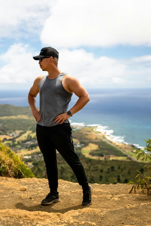 the man is standing on top of the mountain looking at soing