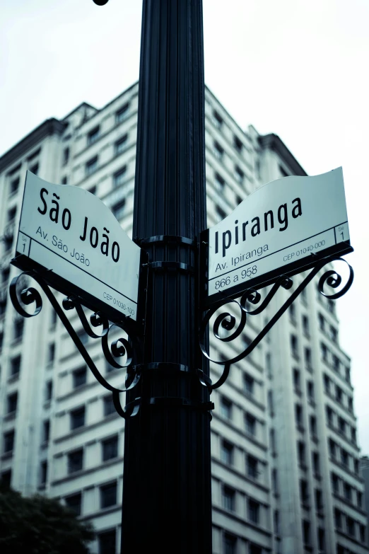 a street sign on a lamp post in front of an office building