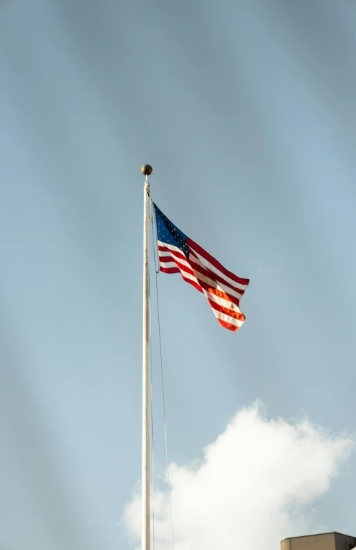 american flag waving in the wind over the university