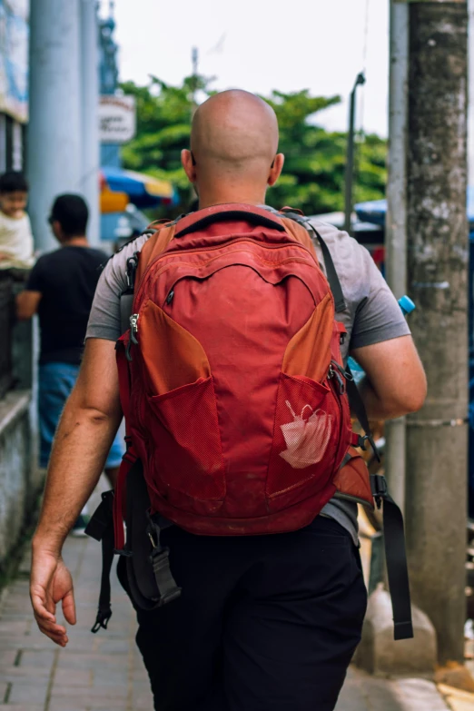 a man is walking down the sidewalk in a backpack