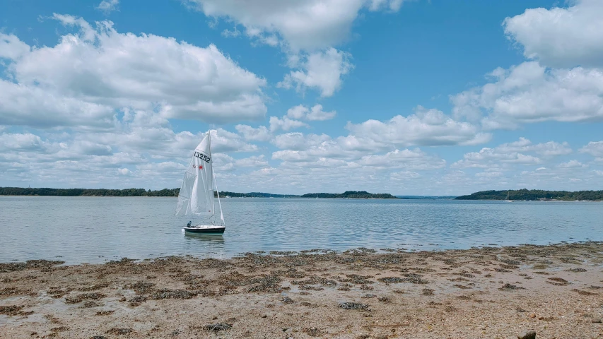 a sailboat in the distance floating on the water