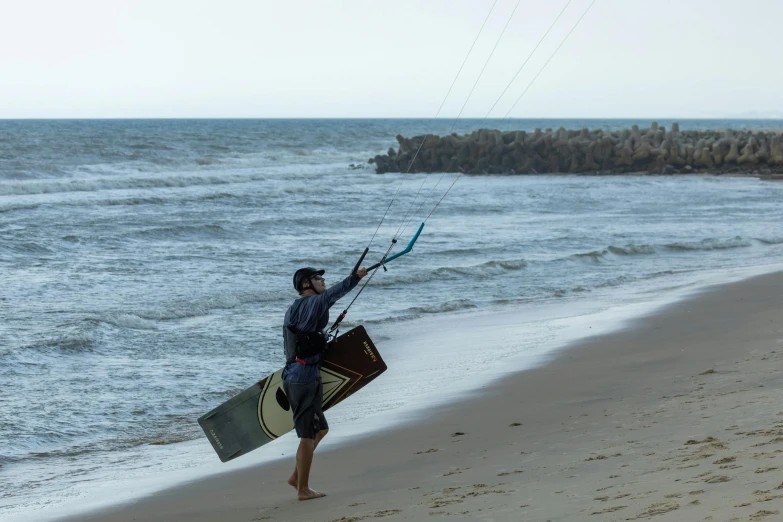 the man carries his surfboard as he comes out of the water