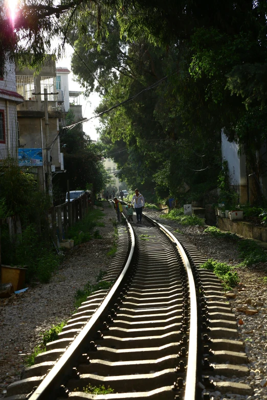 the train tracks lead into the sun light