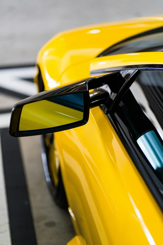 the side view mirror of a yellow sports car