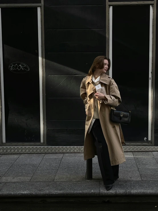 a woman standing on the street in front of large windows