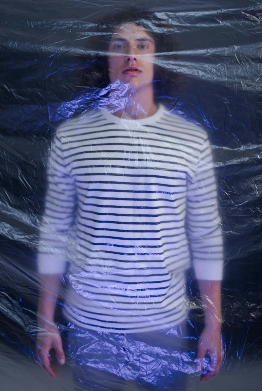 a man posing for a picture while wrapped in plastic
