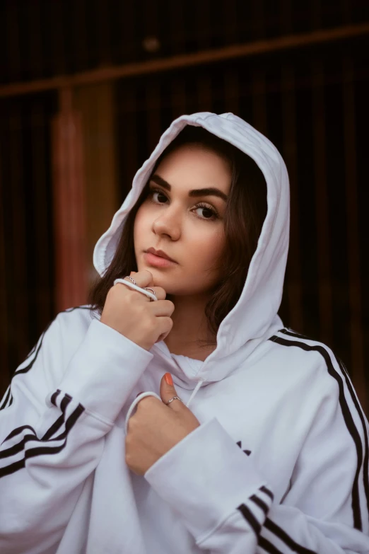 a woman with a hoodie and a pen posing for a picture