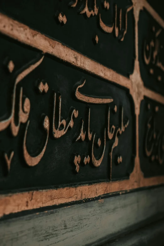 a metal plaque is decorated with arabic writing
