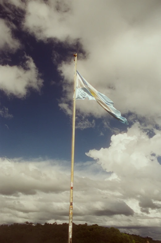 an airplane flies next to a flag on a pole
