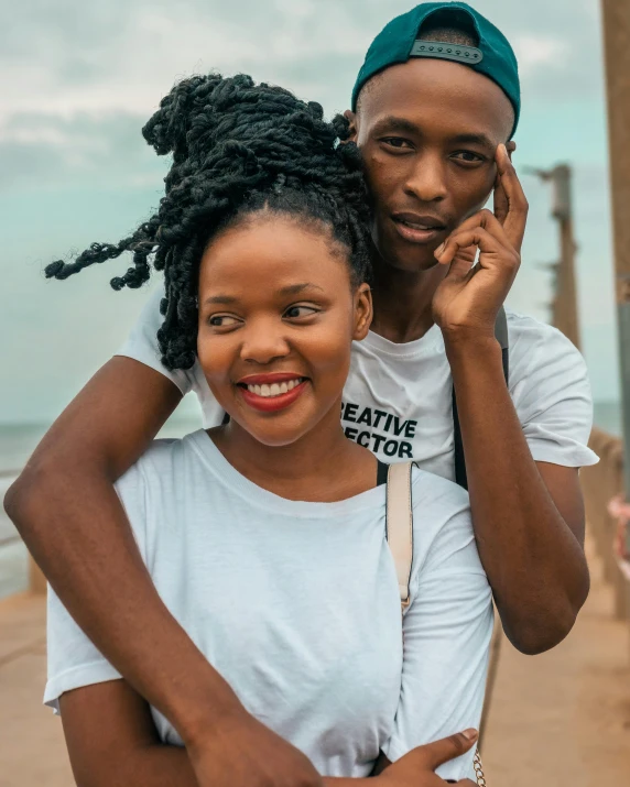 a young man hugs a young woman from behind