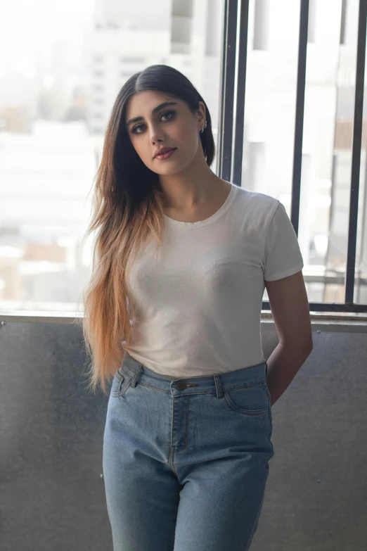 a woman is leaning on a window sill with her hands on her hips