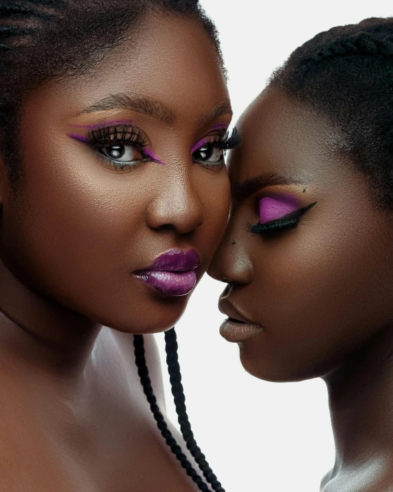 two beautiful black women with bright makeup, posing