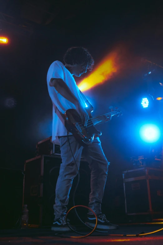 a young man is playing guitar on stage