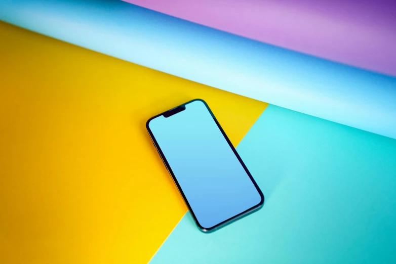 an iphone is displayed on an assortment of colored papers