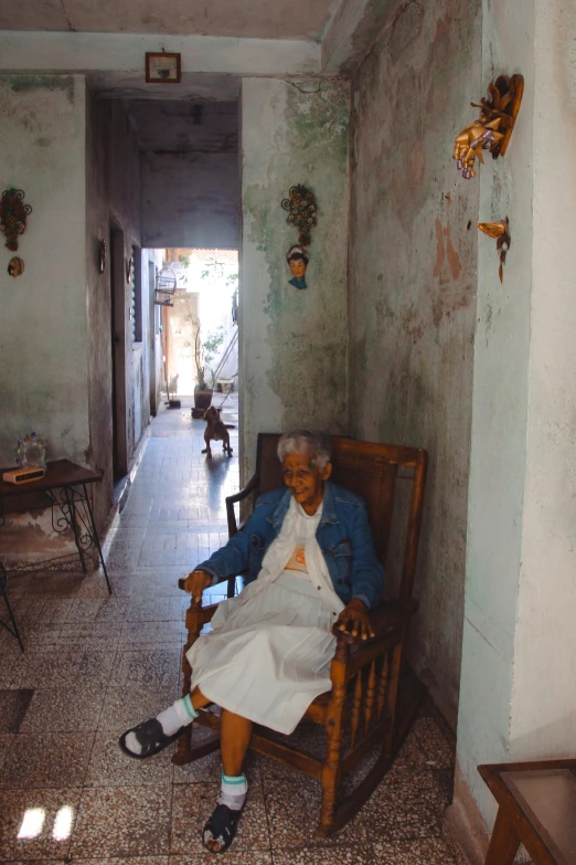 an old woman with a dress sitting in a chair