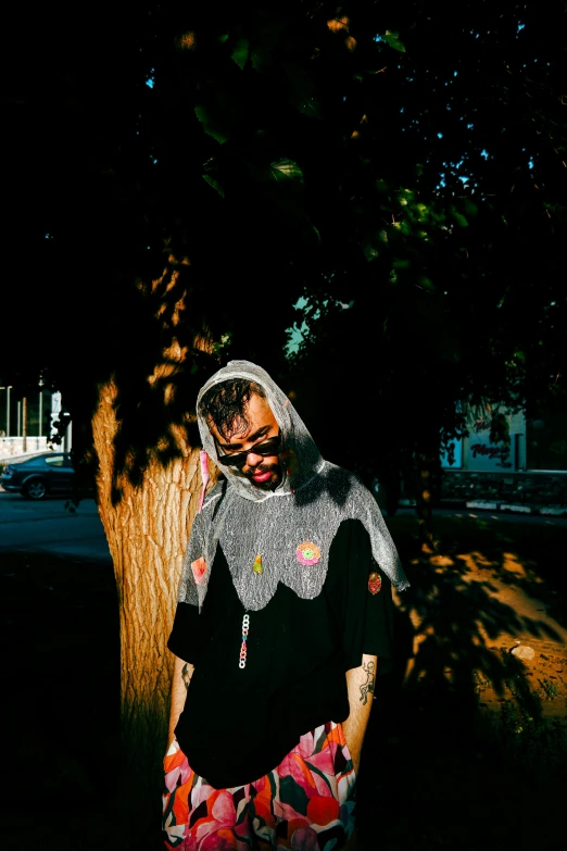 a person leaning against a tree in the dark