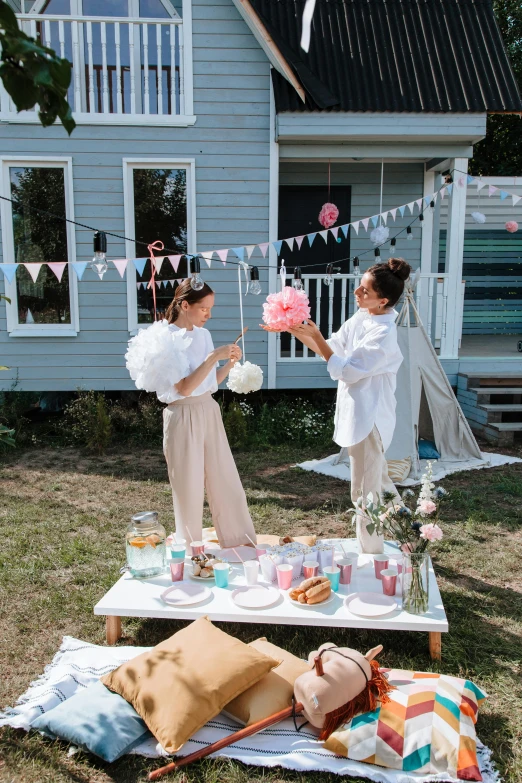 two girls eating cake outside in the grass