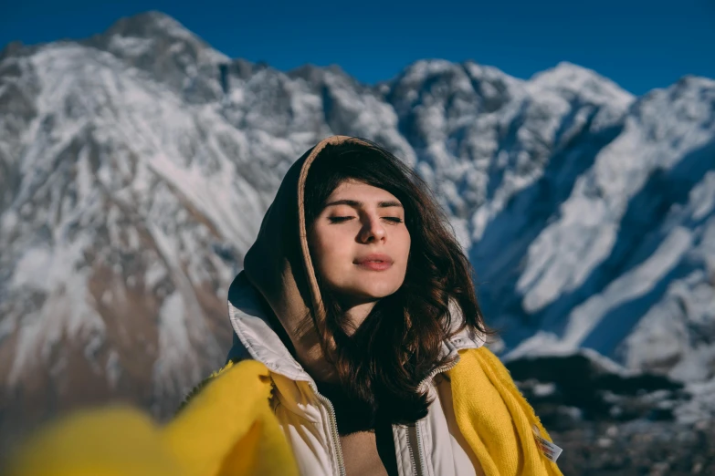 a woman standing in front of snow capped mountains