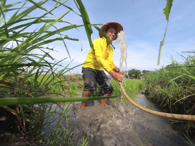 a boy holding a hose in the water