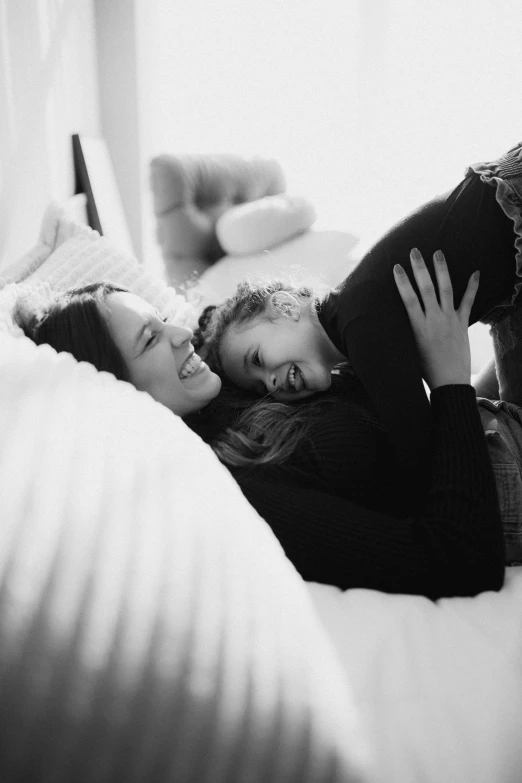 a mother and child lying on top of a bed