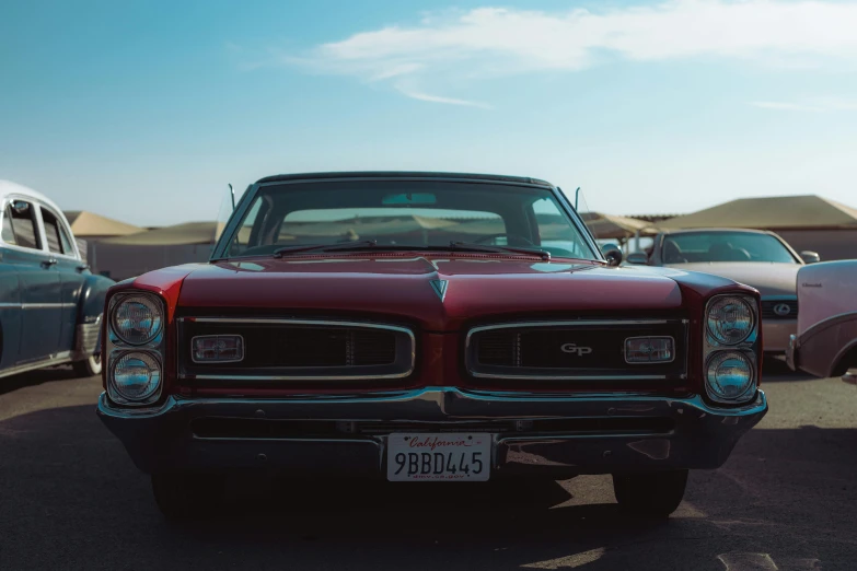 classic cars parked in a parking lot near other vehicles