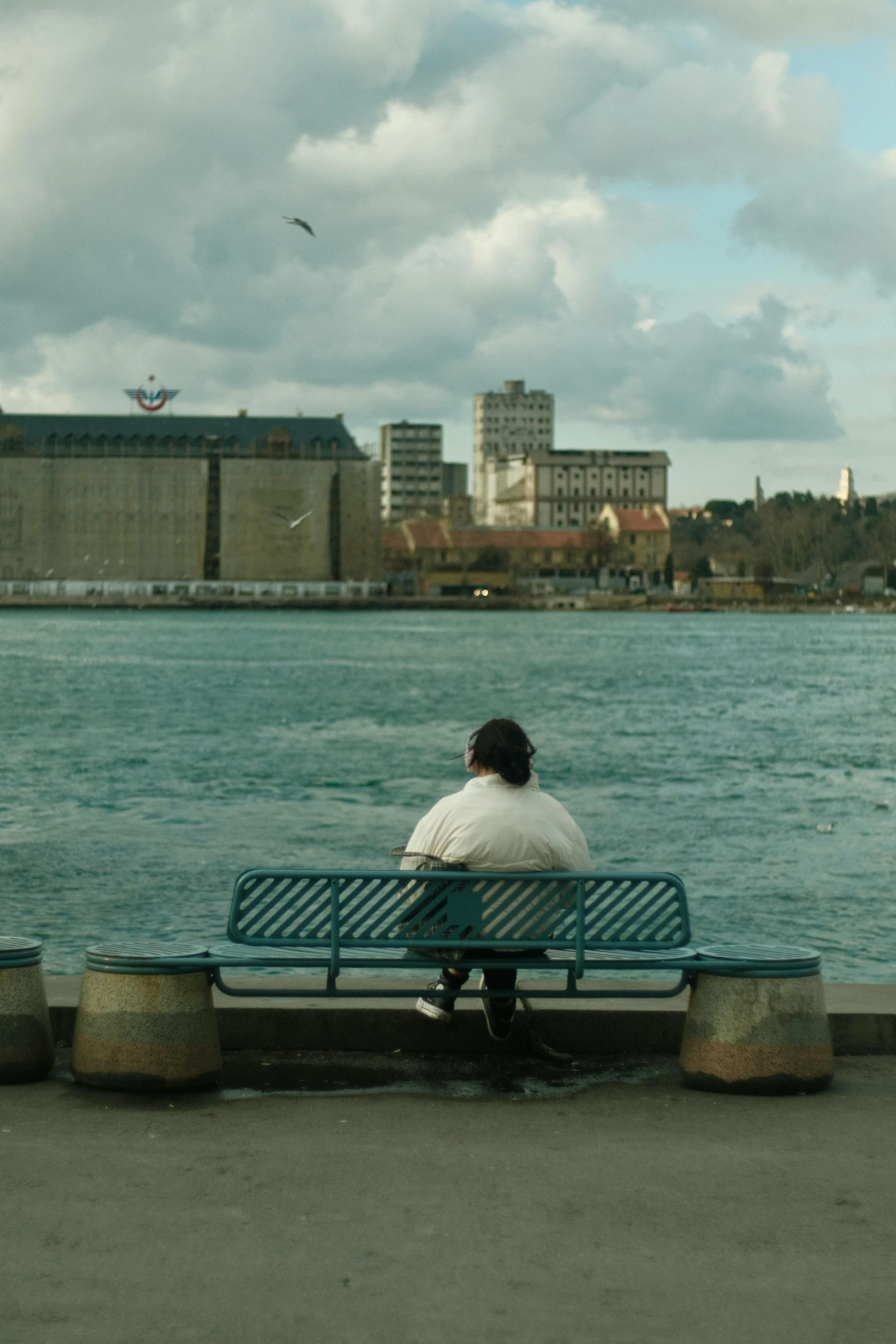 a man is sitting on a bench by the water