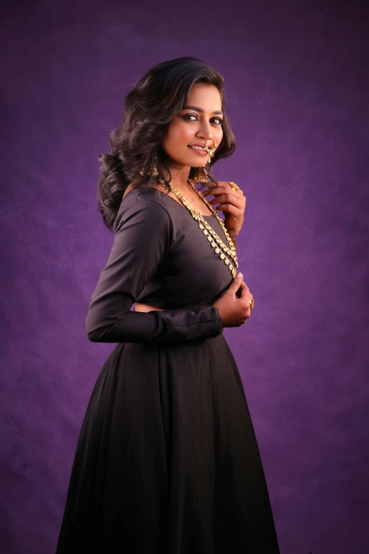 woman standing and smiling wearing a black dress