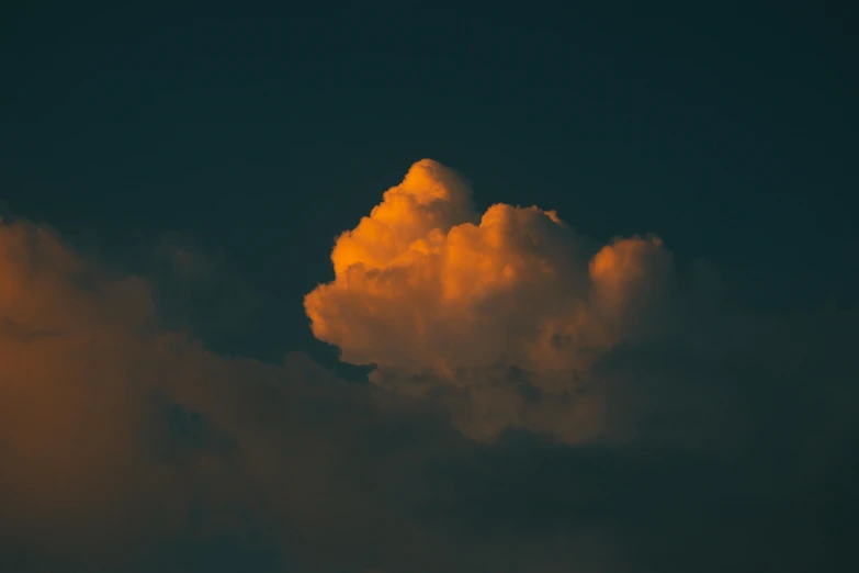 orange clouds form the silhouette of a jet airliner