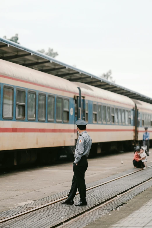 a man standing on the platform next to a train