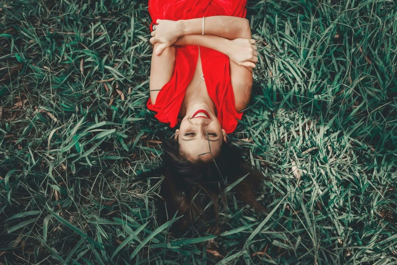 a woman lies on her back in the middle of tall grass