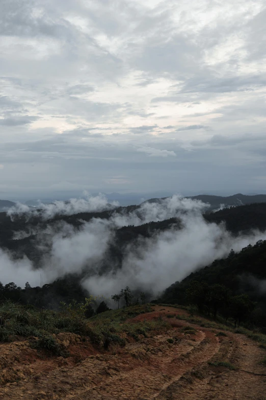 a hill view of clouds on the ground