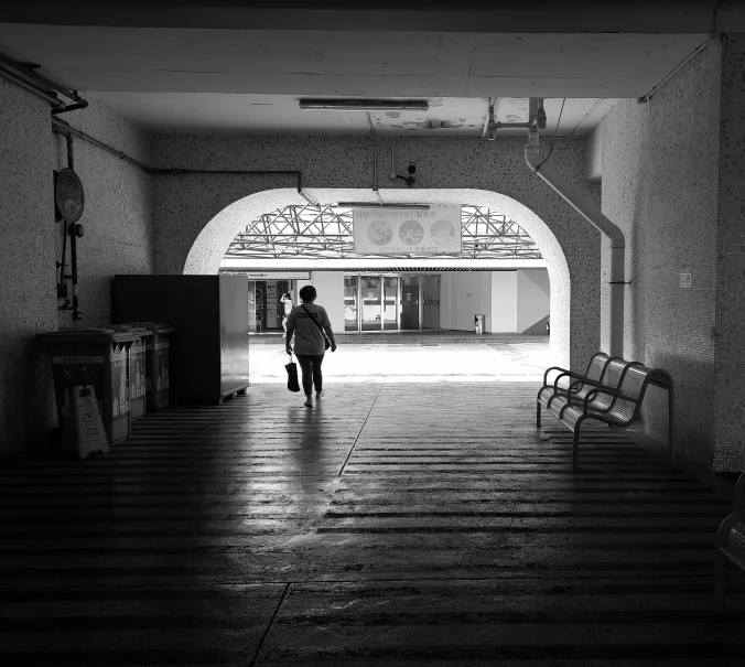 black and white po of man walking into a building