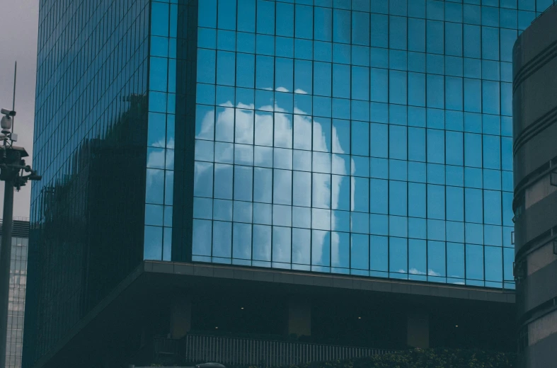 there is the reflection of a building with a cloud in it