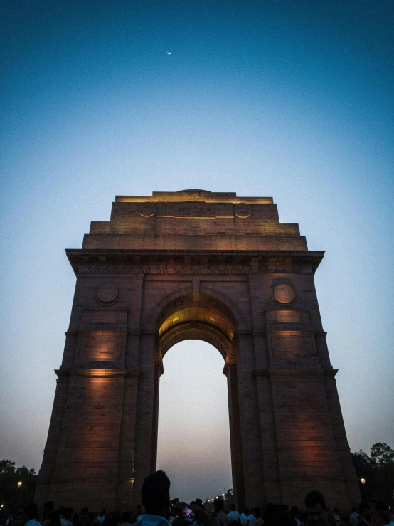 people standing next to a monument at night