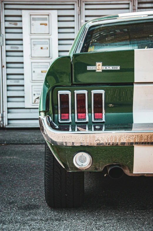 the back end of a green mustang mustang mustang with chrome and white stripes