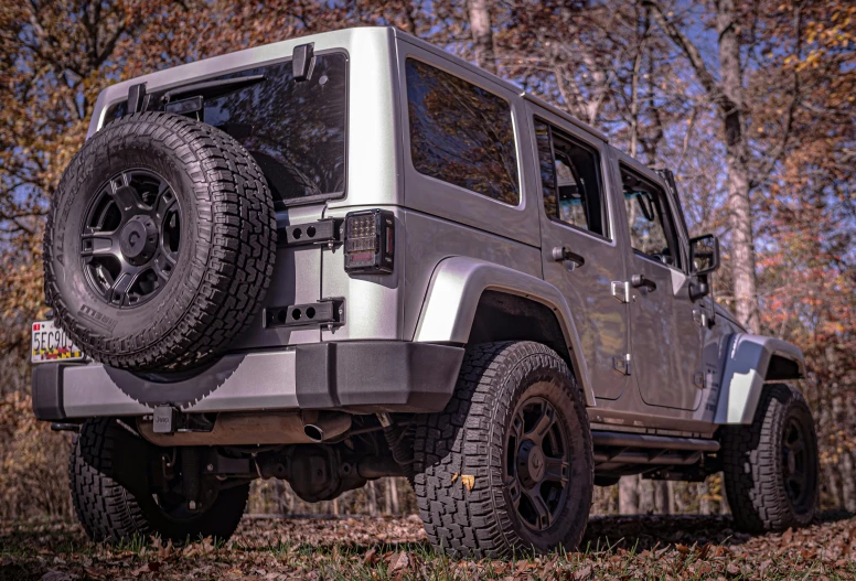 the jeep is driving through the woods on the trail