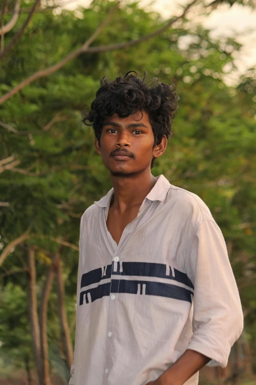 a man standing outside near a forest