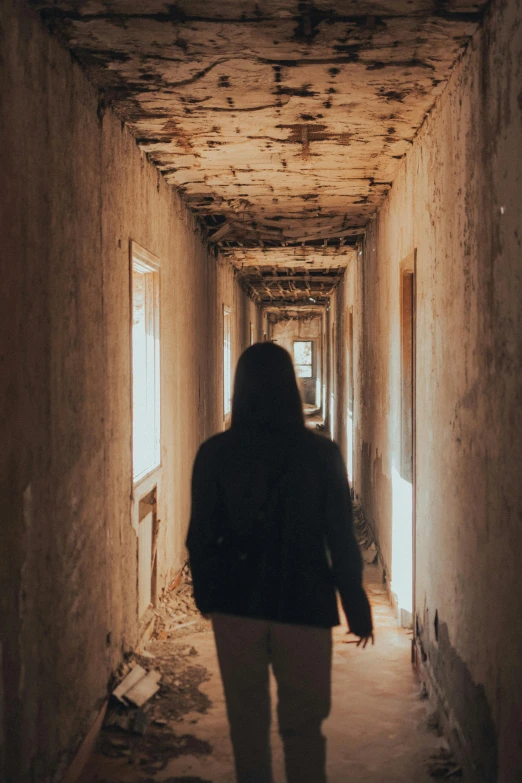 person walking in the tunnel or corridor of a hospital building