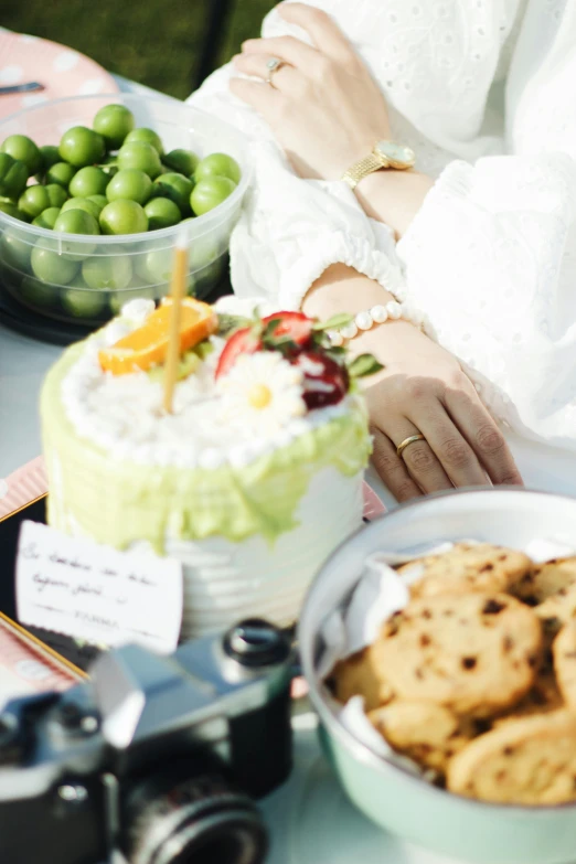 the woman has her hands in her purse sitting at the table with a cake