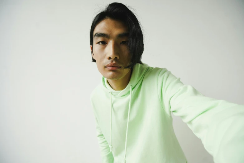 a man wearing a green sweatshirt and hoodie