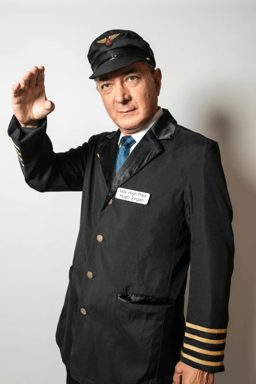 a man in a suit and cap holding his hand out